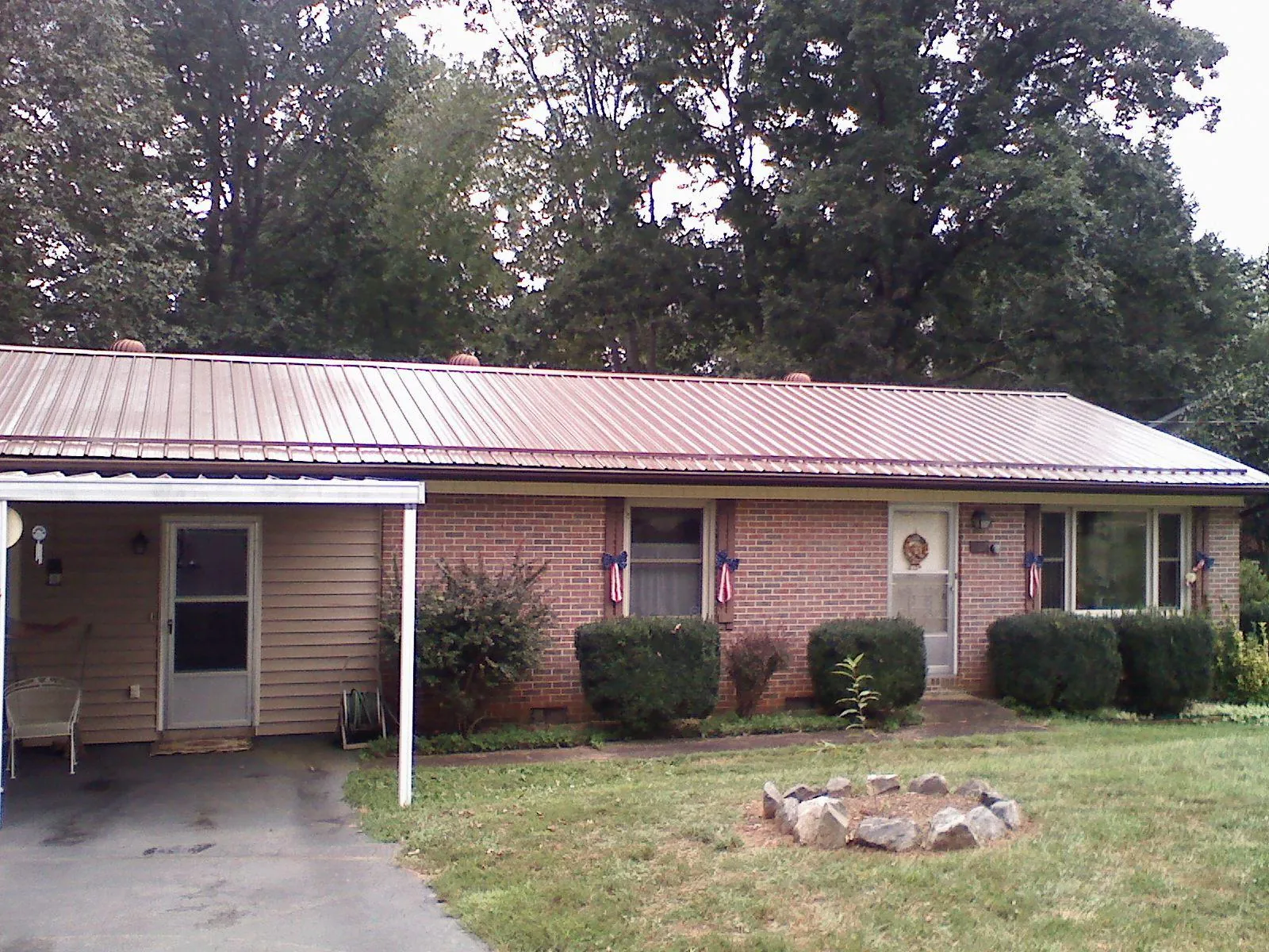 Bronze metal roof and carport on a brick ranch home — Roof Repair work by our crew in Currie